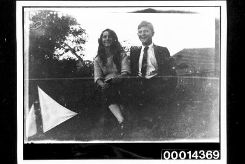 Young woman and man sitting in a suburban garden