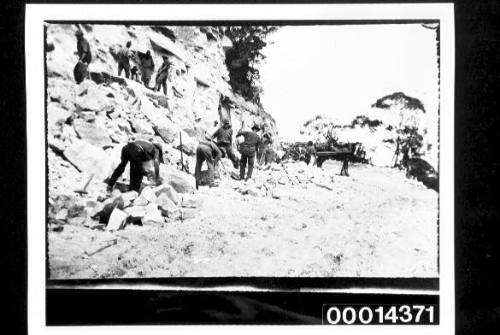 Labourers working on a rocky road
