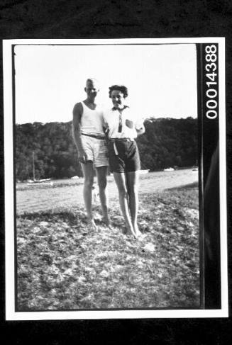 A young couple standing on a grassy foreshore