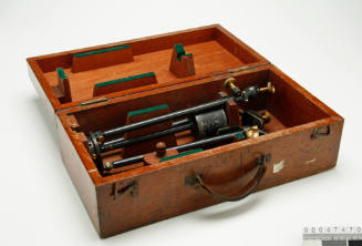 Wooden box containing a tripod, metal bolts and tripod accessories