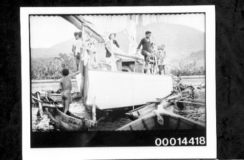 New Guinean visitors on the deck of yacht SIRIUS surrounded by outrigger canoesl