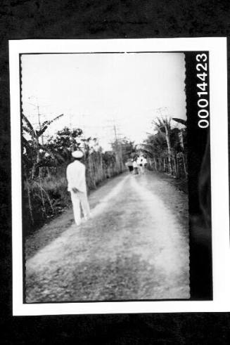 Uniformed man walking along a dirt road at Buton, Indonesia
