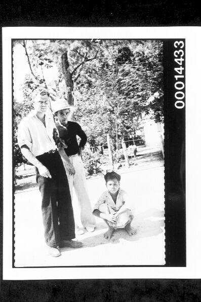 Standing with a man and young boy along street in Buton, Indonesia