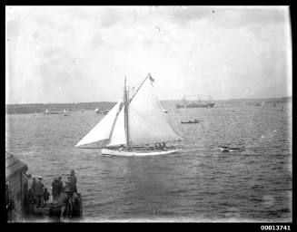 Portside view of a yacht towing a dinghy on Sydney Harbour