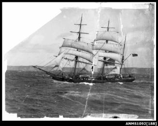 Negative of a three masted barque underway with reduced sail