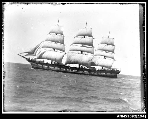 Negative of a three masted full rigged ship with the sails set and underway