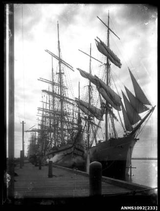negative of several square rigged sailing ships moored behind each other at the wharf including the INVERNESS