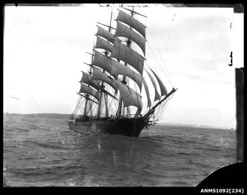 Negative of a three masted full rigged ship with sails set and underway