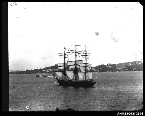 Three masted full rigged ship at anchor with unfurled sails