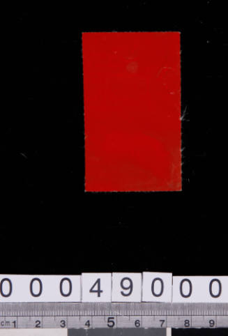 Synthetic material sample with red painted coating