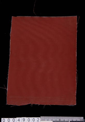 Synthetic material sample with burgundy painted coating