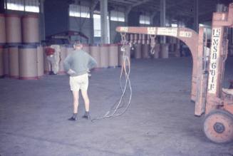 Slide depicting a man standing in front of a forklift