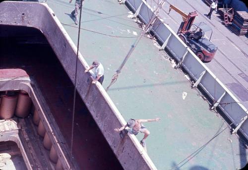 Slide depicting two men looking into the cargo hold