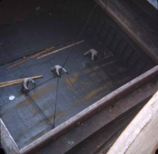 Slide depicting three man in the cargo hold working with chains