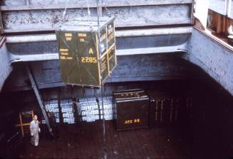 Slide depicting a metal crate being lowered into the cargo hold