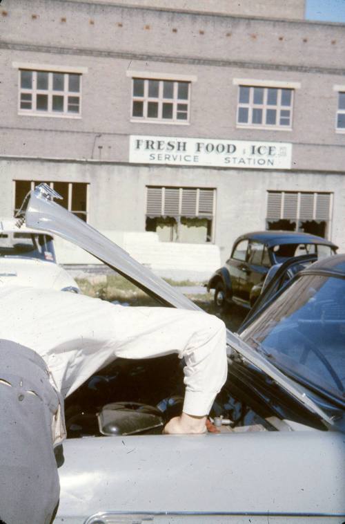 Slide depicting man leaning into an open bonnet of a car