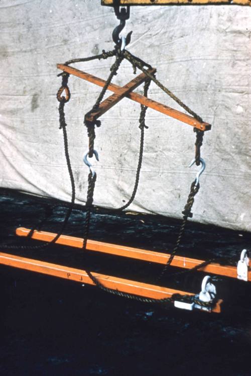 Slide depicting a wooden and hook lifting device