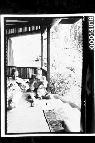Harold Nossiter Snr and a friend drinking on a bungalow verandah, Trinidad, West Indies