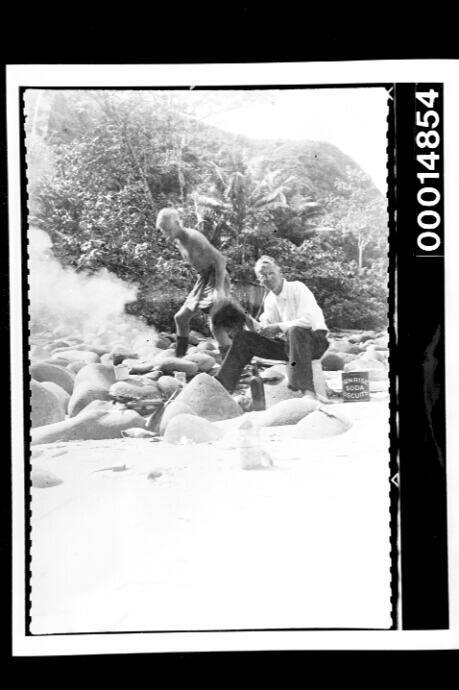 The Nossiters cooking a meal among rocks at a Cocos Islands beach