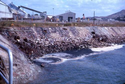 Slide depicting shed with machinery visible in the back ground