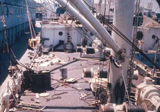 Slide depicting the deck of a ship with uncoiled ropes alongside the wharf