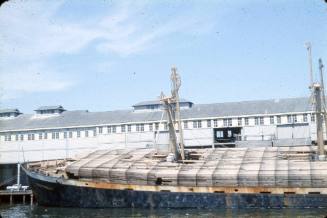 Slide depicting a stack of wooden crates being lifted by a crane