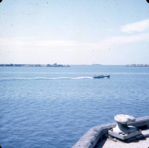 Slide depicting a small boat in a protected harbour