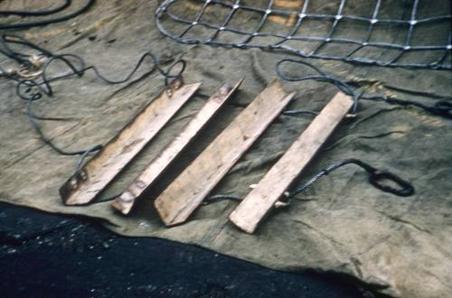 Slide depicting metal poles laying on a tarp