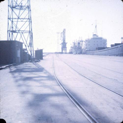 Slide depicting a wharf with a large vessel moored alongside