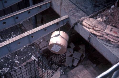 Slide depicting a cylindrical shaped object being lowered from cargo hold