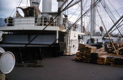 Slide depicting wooden piles stored on deck