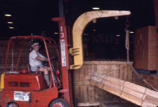 Slide depicting a stack of wooden planks being moved by a forklift