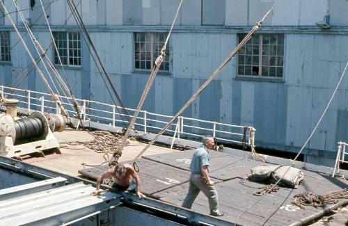 Slide depicting two men on the deck of a cargo ship