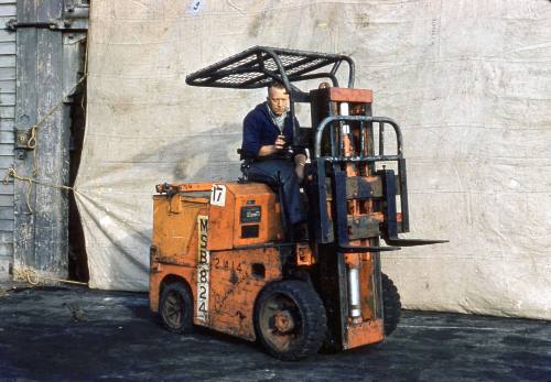 Slide depicting a man on an orange forklift