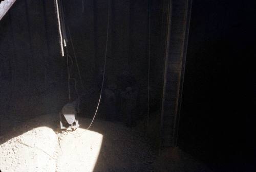 Slide depicting men standing inside a cargo hold area filled with gravel