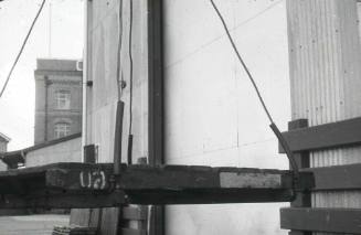 Slide depicting suspended pallet before the doors of a warehouse