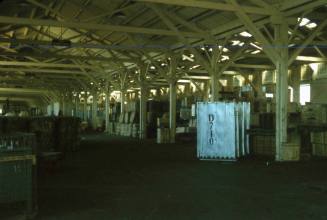 Slide depicting the interior of a warehouse with stacked cargo