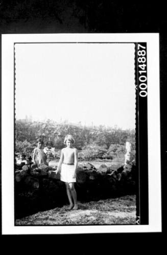 Young girls stand either side of a rocky wall, Galapagos Islands