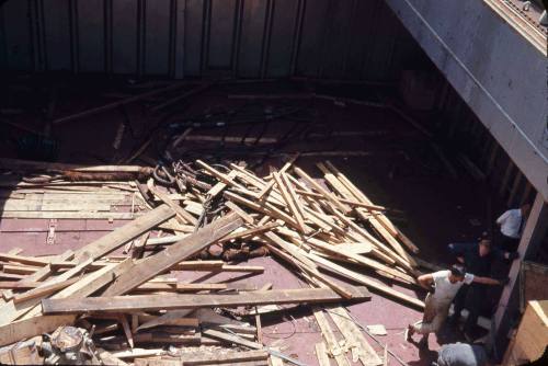 Slide depicting scattered wooden planks over the floor of a cargo area