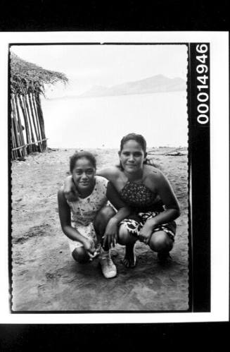 Two young girls pose for a photo on a beach at Bora Bora
