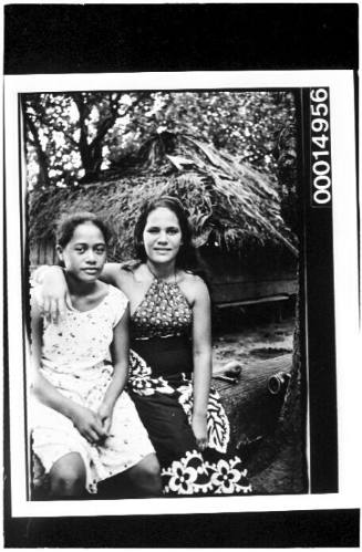 Two Polynesian girls seated on a log, Bora Bora