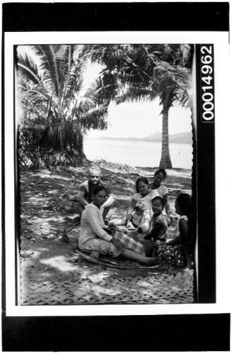 Richard Nossiter sits with a group of women and children in Bora Bora