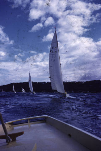 Image looking from a sailing boat back at other boats sailing behind it