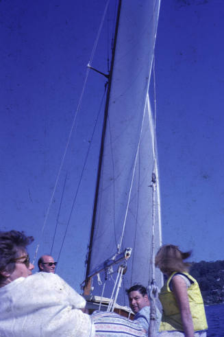 Image of two men and two women sitting on a sailing boat