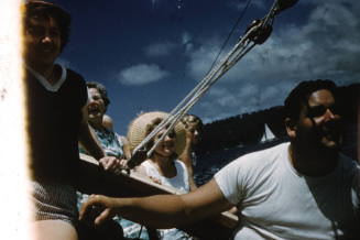 Image of group of people sitting onboard a sailing boat on the water
