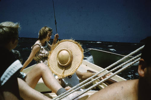 Image of group of people sitting onboard a sailing boat on the water