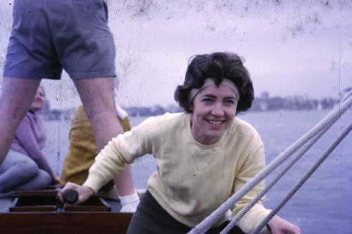 Image of a woman holding the tiller of a boat