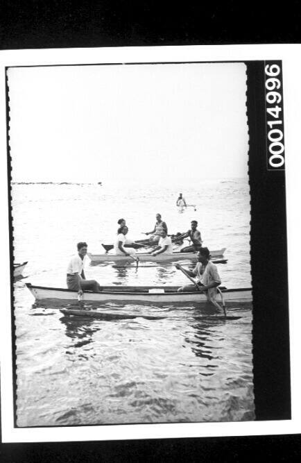 Women and men paddling in outrigger canoes off Rarotonga Island