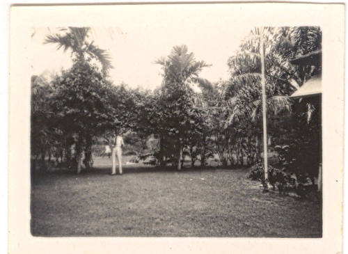 Photograph depicting Basil Helm standing in a tropical garden