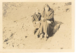 Photograph depicting a woman and a girl sitting on a rock